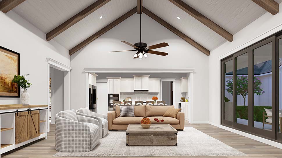 Great room interior of Plan 82761 with vaulted ceiling, exposed beams, and stone fireplace