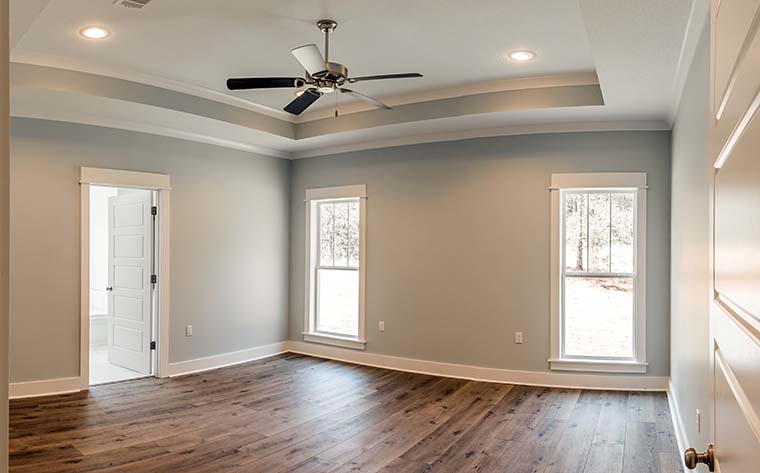 Master suite in Farmhouse Plan 56911 with spa-like bath, dual vanities, soaking tub, walk-in shower, and direct access to laundry room
