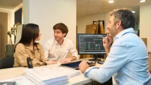 Lender-approved home builder reviewing construction blueprints with homeowner