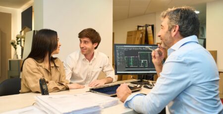 Lender-approved home builder reviewing construction blueprints with homeowner